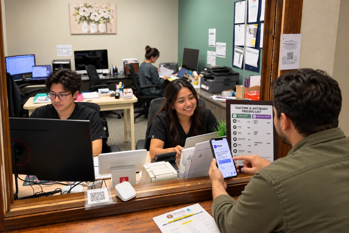 A patient at the clinic's front window showing a staff member the Muse conversation on his phone, with the front office behind her.